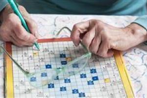 womans-hands-with-crossword-puzzle-and-glasses